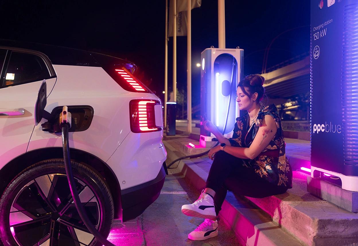 Femeie care își încarcă mașina la una din stațiile de încărcare PPC blue