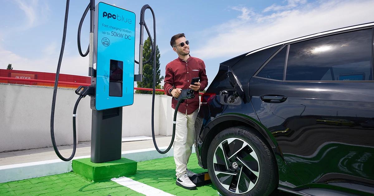 Bărbat care se pregătește să conecteze stația de încărcare la mașina electrică