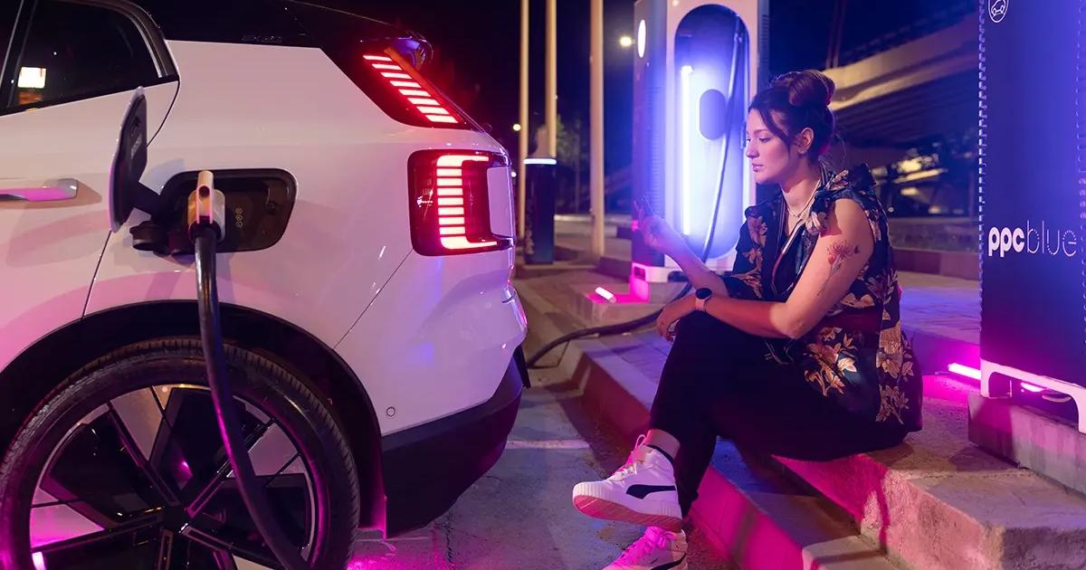 Femeie care își încarcă mașina electrică la stația de încărcare PPC blue